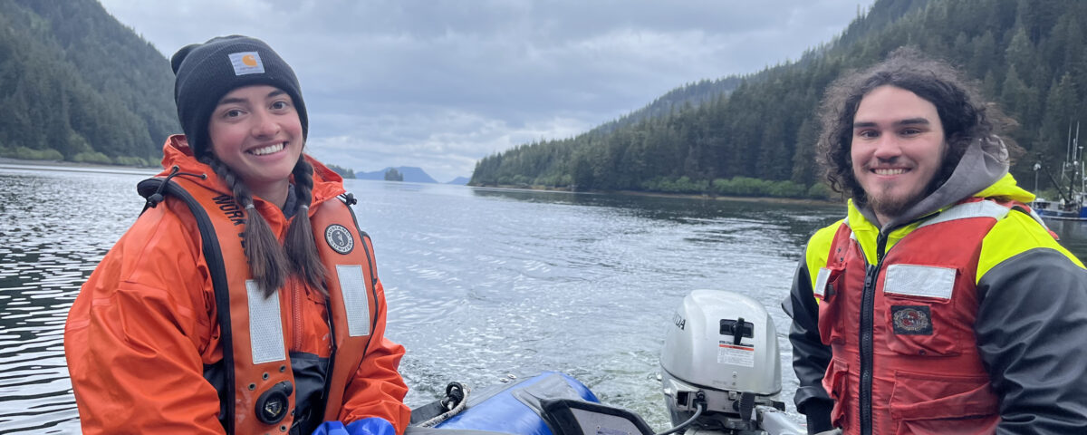 One male and one female fish researcher sitting on a boat in the ocean