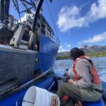 Large research vessel (seine boat) next to smaller boat