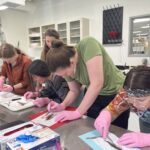four people performing a fish dissection in a lab