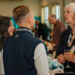 Two elderly women conversating with a young man and woman.